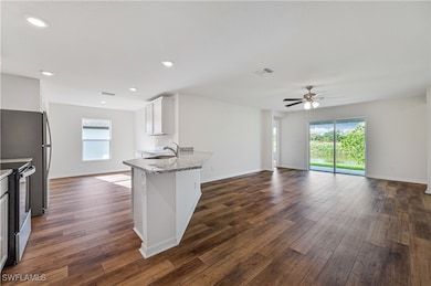 Kitchen with white cabinetry, a wealth of natural