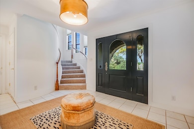 Tiled entryway featuring stairway