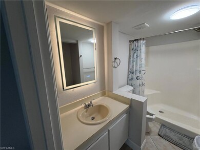 Full bathroom featuring a shower with shower curtain, vanity, tile patterned floors, and a textured wall
