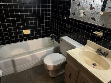 Full bathroom featuring vanity, toilet, tile walls