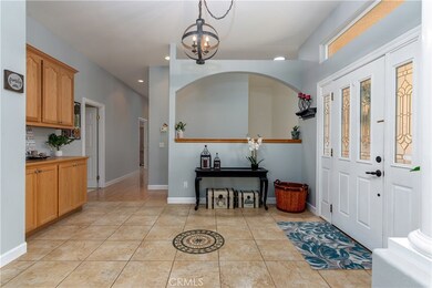 Huge entry way offers built in cabinets, custom lighting and tile flooring.
