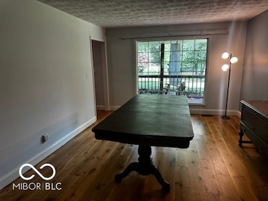 dining space featuring a textured ceiling and wood finished floors