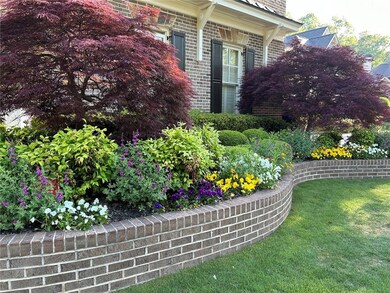 View of property exterior featuring a yard and bri