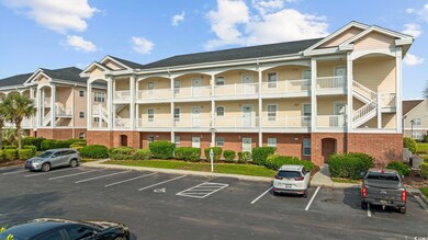 View of building exterior with uncovered parking