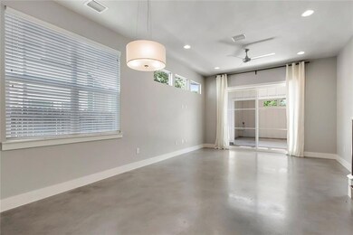 Empty room featuring ceiling fan, finished concre