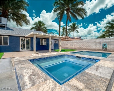 View of swimming pool with an in-ground hot tub, a