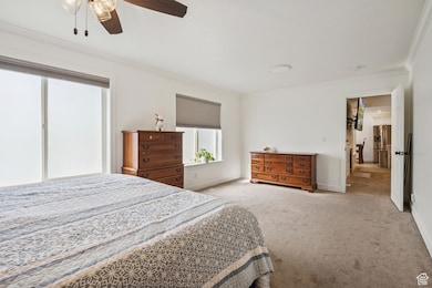 Bedroom featuring crown molding, carpet, stainless steel fridge, and ceiling fan