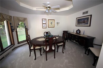 Dining room with tray ceiling and ceiling fan. Aga