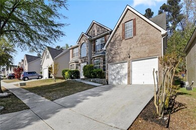 Traditional-style house with an attached garage, driveway, brick siding, and a residential view