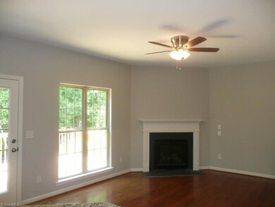 Large den with hardwoods and fireplace open to kitchen