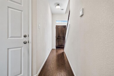Hall featuring dark wood finished floors, a textu