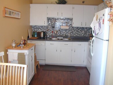 Kitchen with tile backsplash & ceiling fan.