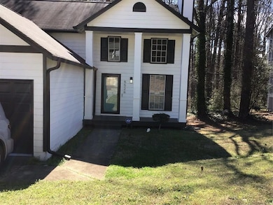 Doorway to property featuring a garage, roof with 