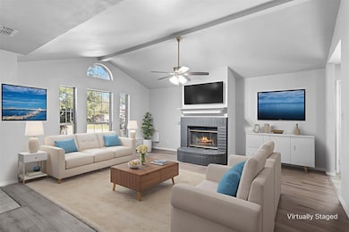 Step into a spacious living room with vaulted ceiling, cozy fireplace, and an abundance of natural light.