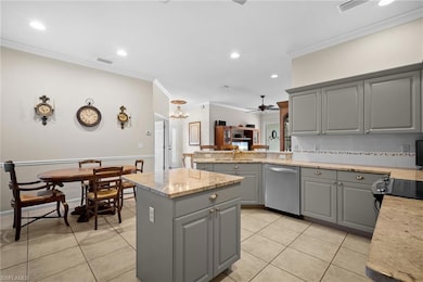 Kitchen with gray cabinetry, crown molding, ceiling fan, tasteful backsplash, and recessed lighting