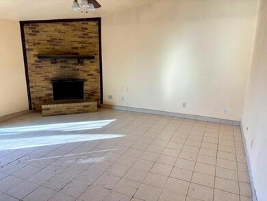 Living room with tile floor and woodburning firepl