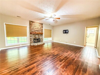 Unfurnished living room featuring ceiling fan, dark wood finished floors, a textured ceiling, and healthy amount of natural light
