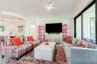 Living room featuring ornamental molding, ceiling fan, and arched walkways