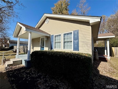 View of property exterior featuring a shingled roof and a porch