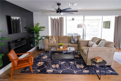 Living room featuring baseboards, a ceiling fan, w