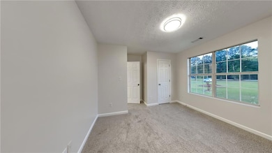 Spare room featuring baseboards, light colored car