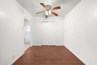 Unfurnished bedroom with wood finished floors, a ceiling fan, and a closet