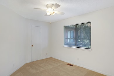 Spare room with light colored carpet, a textured ceiling, and a ceiling fan
