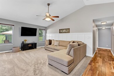 Living room has vaulted ceiling with ceiling fan!