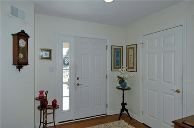 Step into the foyer with warm hardwood flooring an