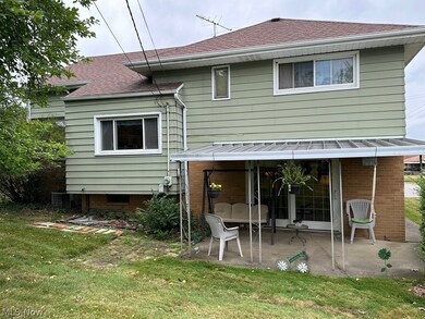 Back of house featuring a patio area, central AC unit, and a lawn
