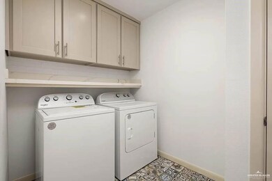 Laundry area with baseboards, washing machine and dryer, and cabinet space