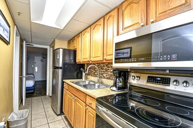 Kitchen with decorative backsplash, light tile pat