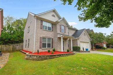 Traditional home featuring brick siding, concrete driveway, and a garage