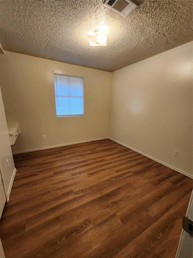 Unfurnished room with dark wood-type flooring and