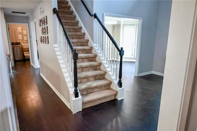 Stairs with hardwood / wood-style flooring and baseboards