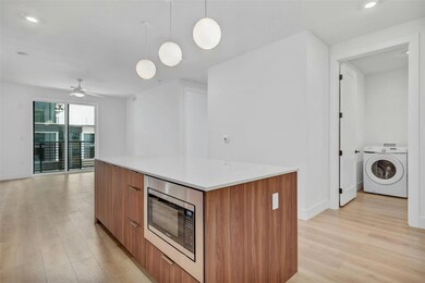 Kitchen featuring washer / dryer, modern cabinets