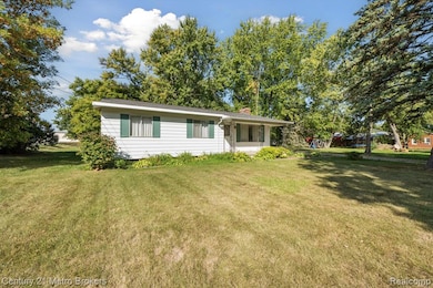 View of front of house featuring a chimney and a front lawn
