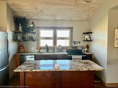 Kitchen featuring open shelves, stainless steel appliances, light stone counters, a center island, and wood ceiling