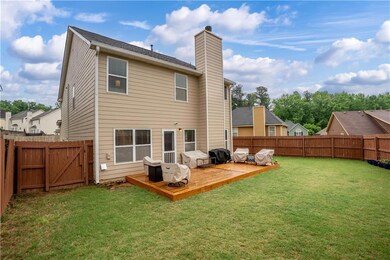 Rear view of house with a chimney, a deck, and a g