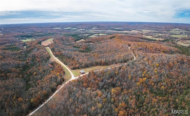 Aerial view of property's location with a heavily wooded area