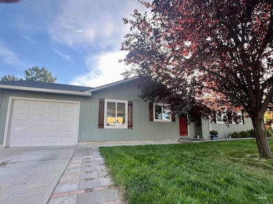 Ranch-style home featuring a front lawn, a garage, driveway, and roof with shingles