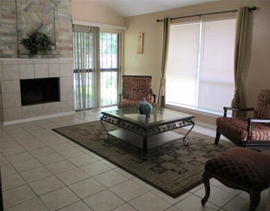 Spacious living room has a beautiful brick accented gas log fireplace, built in book shelving and underneath storage, and ceiling fan.  Adjacent to backyard entry and exit door with updated blinds for quick access to private backyard.