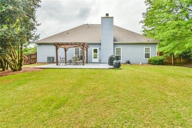 Back of house featuring a patio, a chimney, a perg