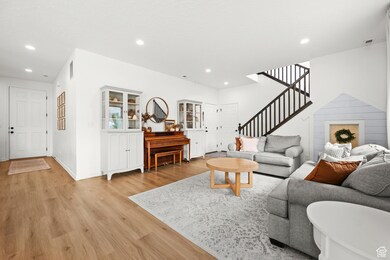 Living room featuring recessed lighting, light wood finished floors, and stairs