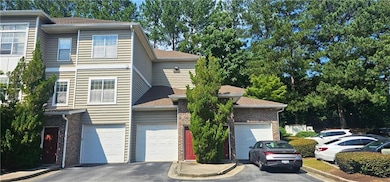 View of front of property featuring driveway, brick siding, and roof with shingles