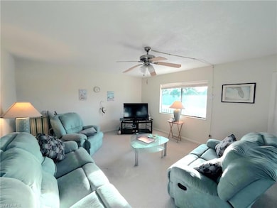 Living area featuring light colored carpet and ceiling fan