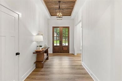 Entryway featuring wooden ceiling, baseboards, lig