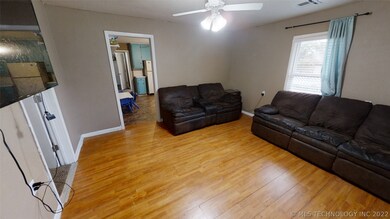 Living room with ceiling fan and vinyl windows. Do