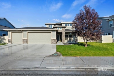 Prairie-style house featuring an attached garage, a front yard, stone siding, and concrete driveway