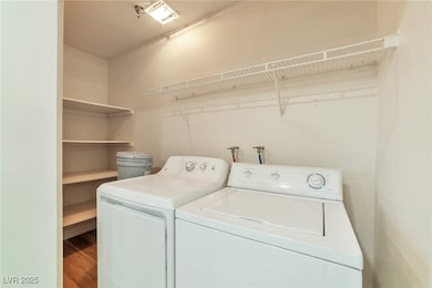 Washroom with washer and clothes dryer and wood fi